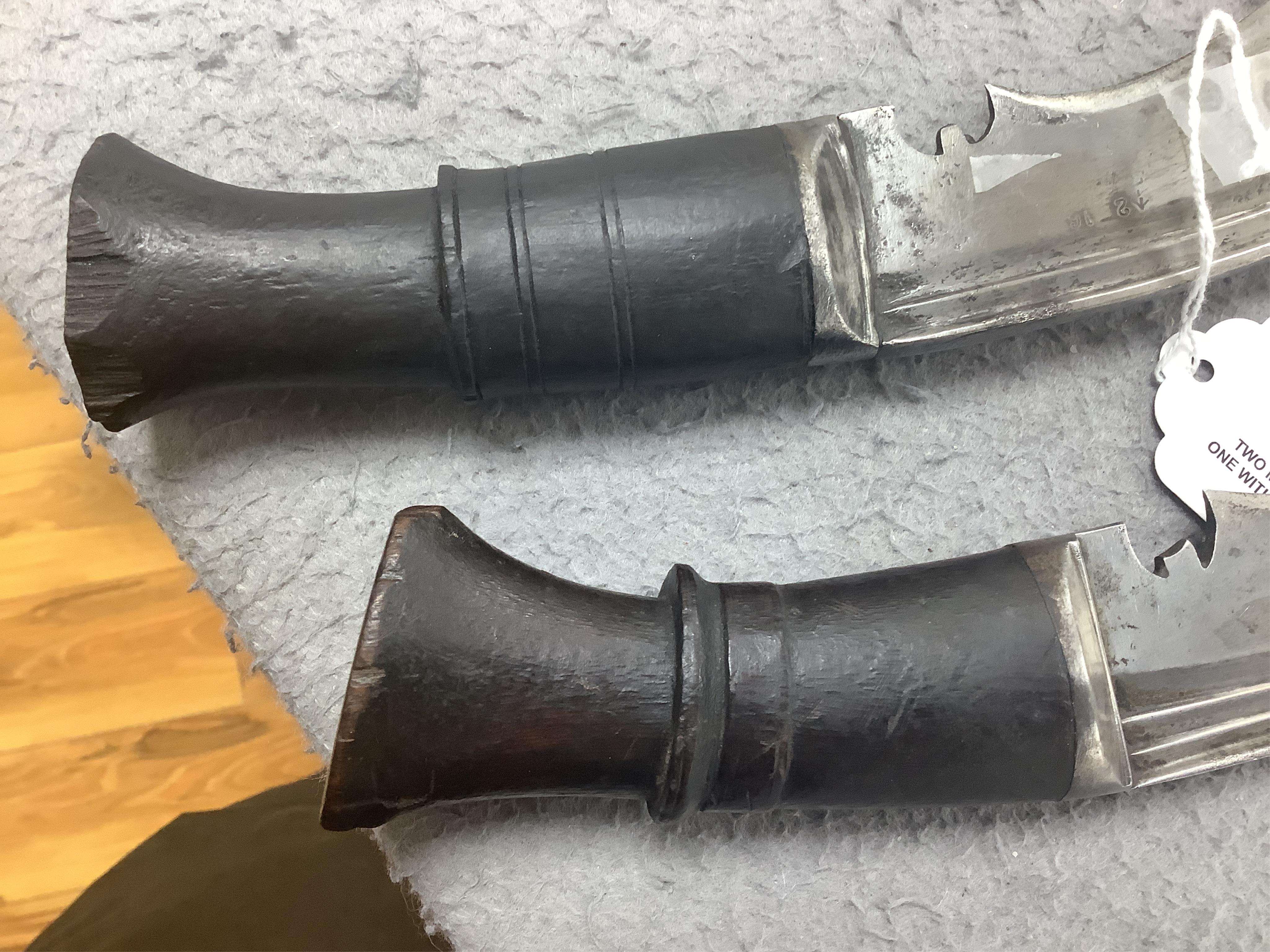 Two military kukri; one with blade stamped with British government ownership mark and issue date February 1916, with wooden handle, no scabbard and another almost identical with board of ordnance mark issued March 1917.